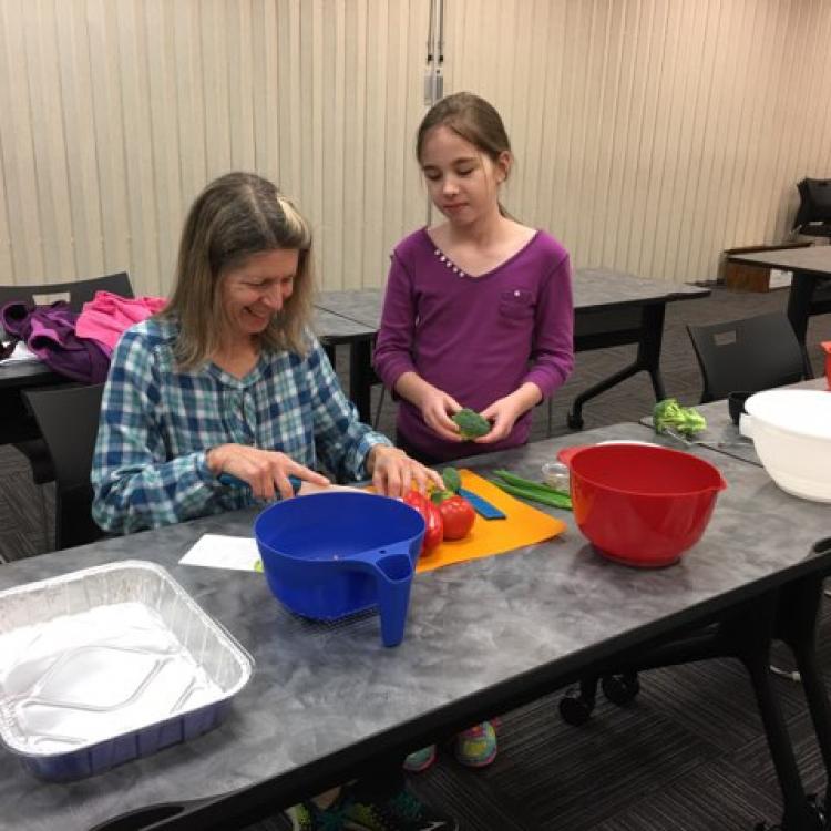  woman and girl cutting vegetables